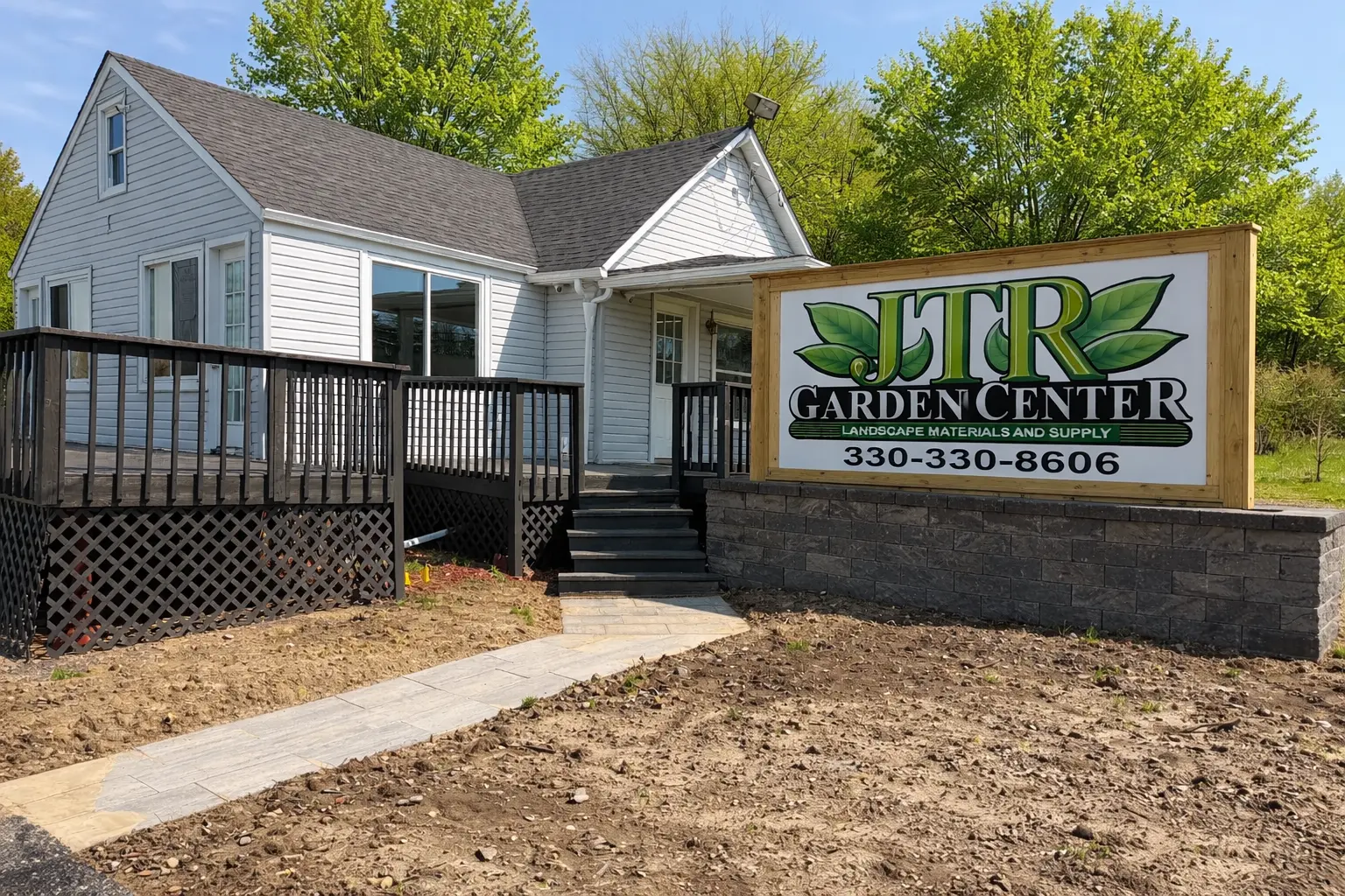 JTR Garden Center storefront in Youngstown Ohio with building entrance, large roadside sign, and landscaped property on a sunny day